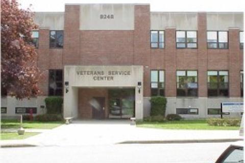 Front view of the 2-story, brick Togus Regional Office. Building 248 is seen on the grey, cement near the top of the building.