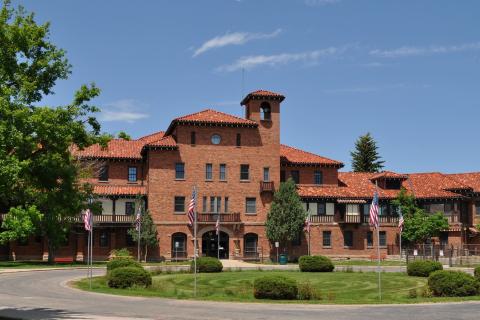 Main entrance to the VA Medical Center in Cheyenne, red brick building, multi-story in circular drive. 