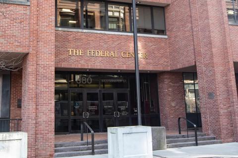large brown brick federal building with sidewalk and stairs that lead to the entrance